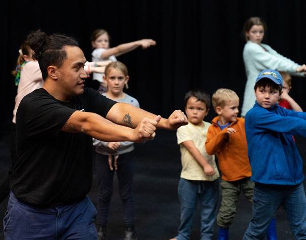 A person shaking hands with a group of children

Description automatically generated with medium confidence