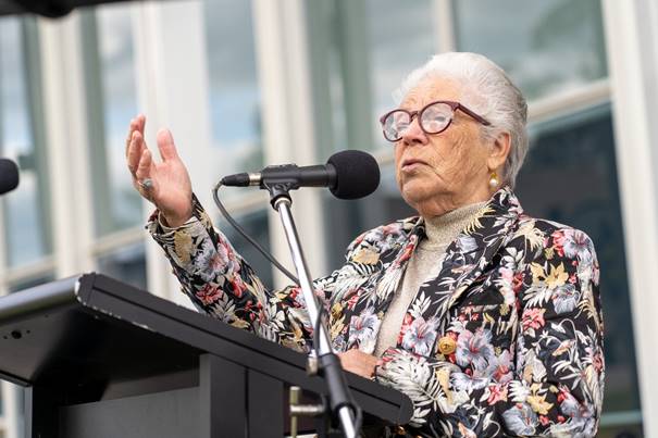 An older person speaking into a microphone

Description automatically generated with low confidence