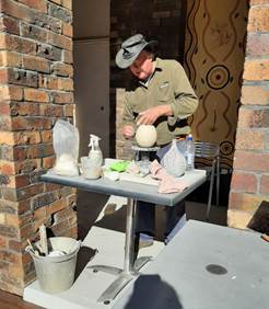 A person in a cowboy hat working on a pottery

Description automatically generated