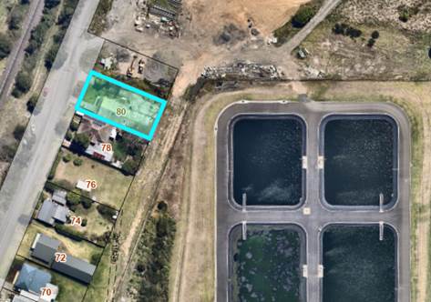 An aerial view of a land with a pond

Description automatically generated