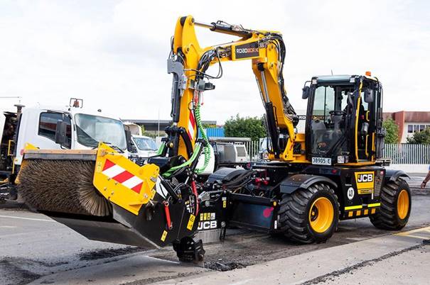 A construction vehicle with a bucket on the side of the road

Description automatically generated