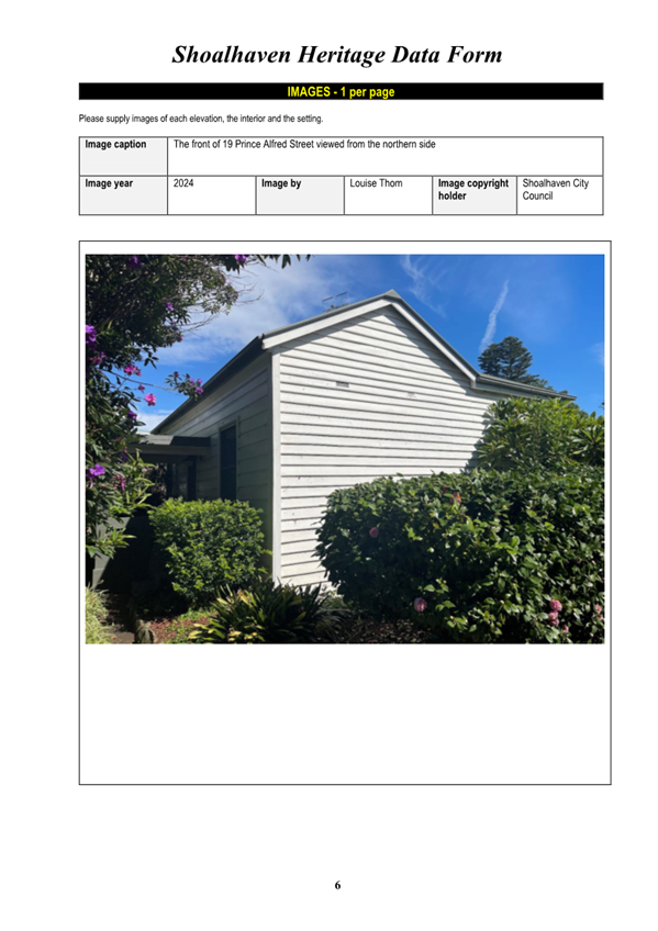 A house with bushes and a blue sky

Description automatically generated