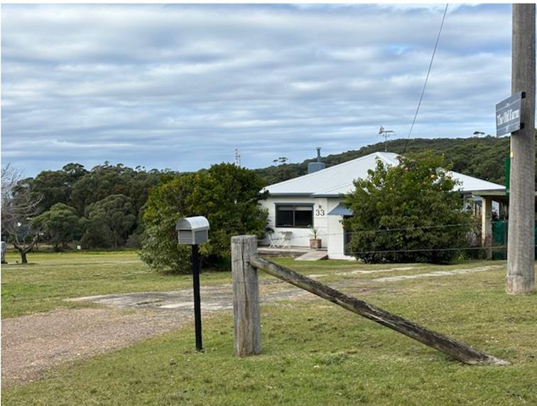 A fenced in yard with a house in the background

Description automatically generated