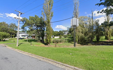 A street with power lines and trees

Description automatically generated