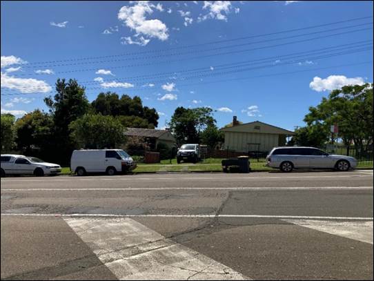 A street with cars parked on it

Description automatically generated