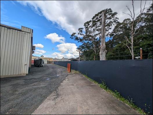 A road with trees and a fence

AI-generated content may be incorrect.