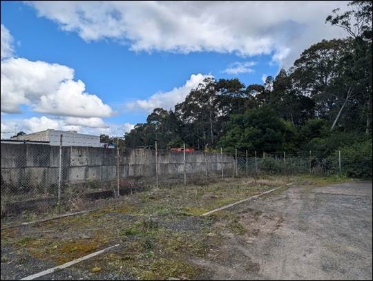 A fenced in area with trees and buildings

AI-generated content may be incorrect.