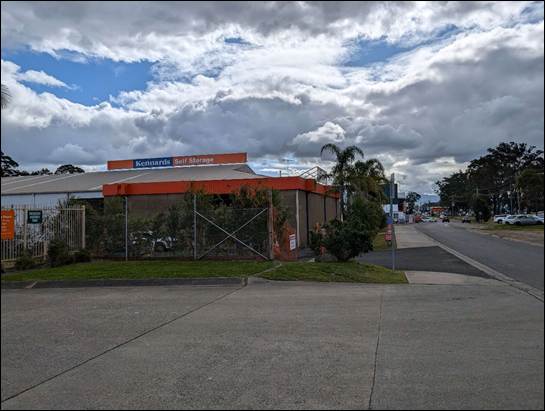 A building with a fence and bushes on the side of the road

AI-generated content may be incorrect.