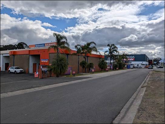 A street with a building and cars on it

AI-generated content may be incorrect.